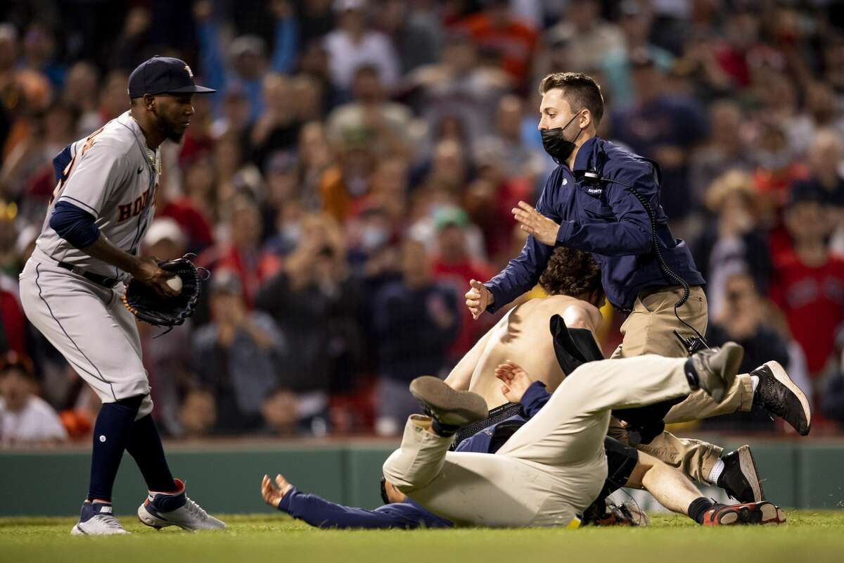 BOSTON, MA - JUNE 10: A fan is tackled as he runs onto the field during the sixth inning of a game between the Boston Red Sox and the Houston Astros on June 10, 2021 at Fenway Park in Boston, Massachusetts. (Photo by Billie Weiss/Boston Red Sox/Getty Images)