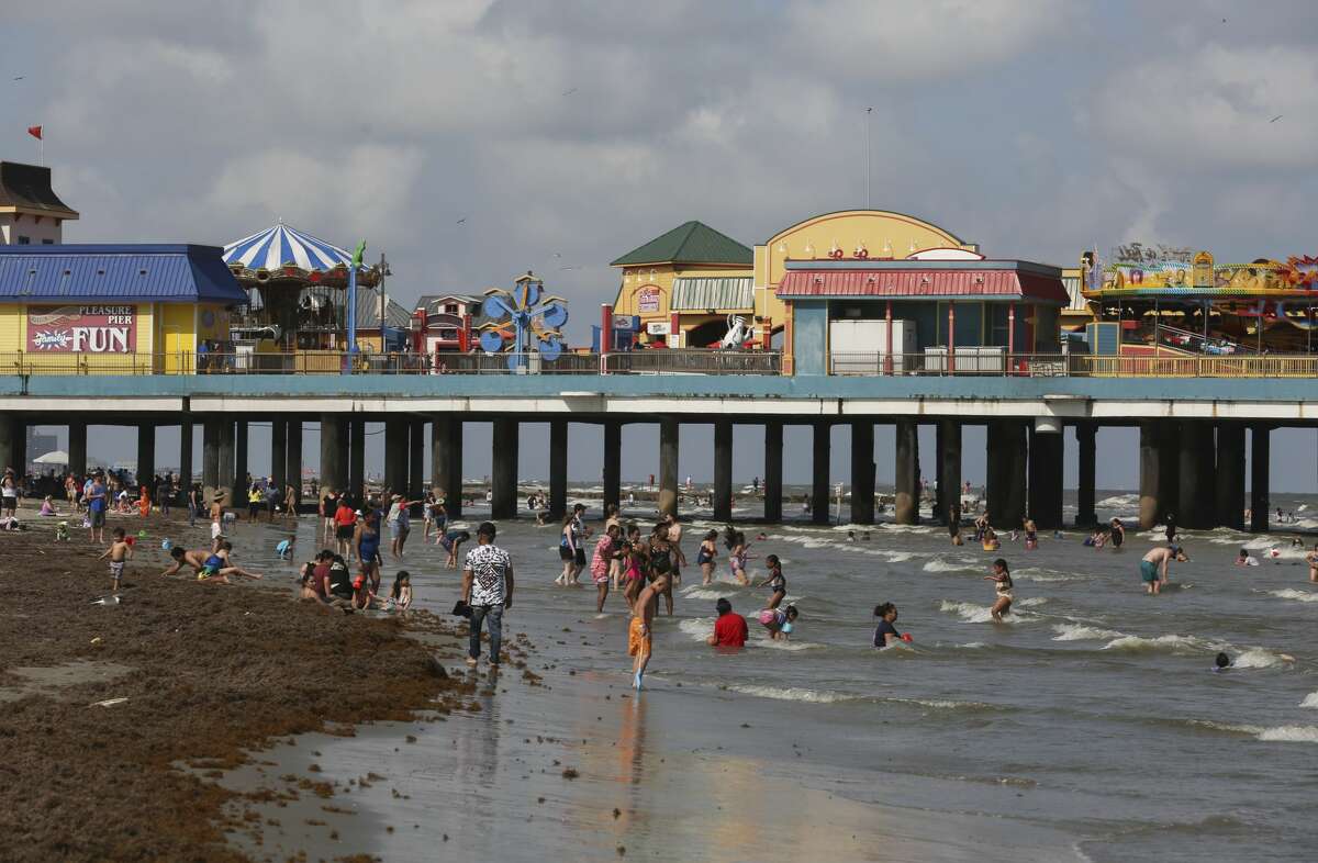 Visiters spend Memorial Day Weekend on the beach near Pleasure Pier on Sunday, May 26, 2019, in Galveston.