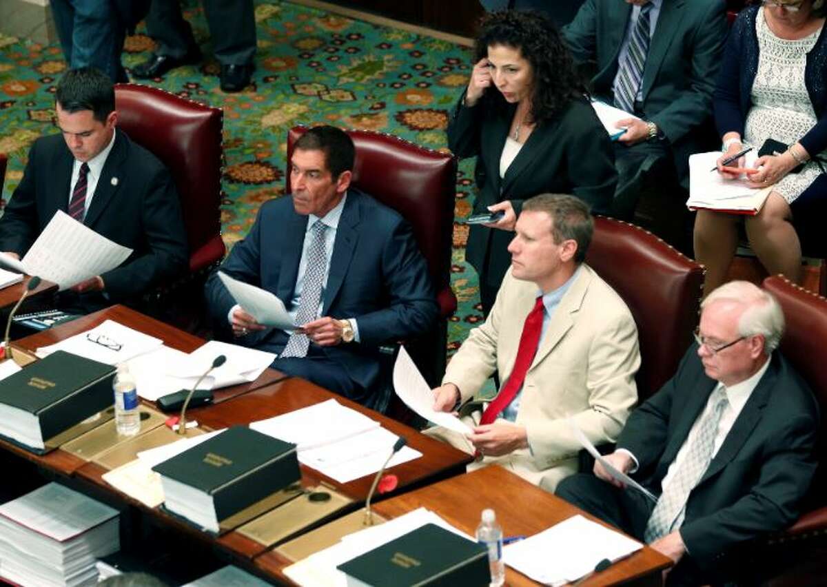 In this 2014 file photo, Diane Savino stands behind four fellow members of the former Independent Democratic Conference (IDC), from left, David Carlucci, Jeffrey Klein, David Valesky, and Tony Avella in the Senate Chamber at the Capitol in Albany, N.Y. They were among the eight New York Democratic state senators who broke with their party to join a group that supported Republican control of the chamber. Valesky was just appointed by Cuomo to serve on the Public Service Commission.