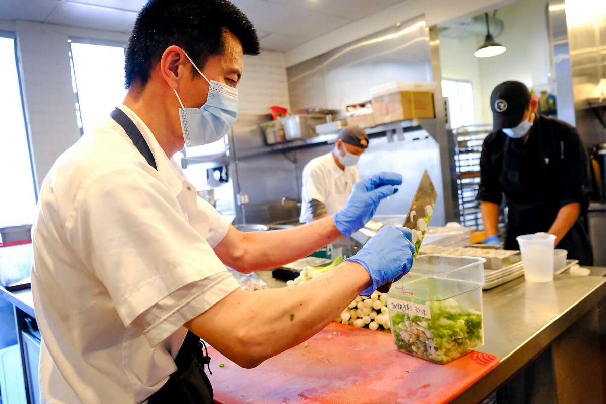 2021年6月10日，星期四，加州旧金山，炒锅厨师Kam Wu在调色板茶馆切大葱。这家点心餐厅正努力招聘足够的员工来满足日益增长的用餐需求。作为一名炒锅厨师，吴通常只会炒锅，但周四他负责切菜、准备菜和做饭。调色板茶馆只有30%的员工，80%的产能在运作，所以员工在他们通常的角色之外填补任何需要他们的地方。总经理Dennis Leung说:“为了做更多的生意，我们需要更多的人手，而我们现在就是人手不够。”