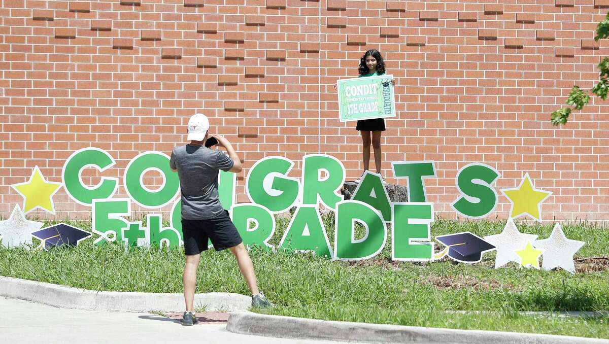 Shreyas Bhavsar takes a photo of his fifth-grade daughter, Maya, on the last day of the 2020-21 school year Friday outside Houston ISD’s Condit Elementary School.