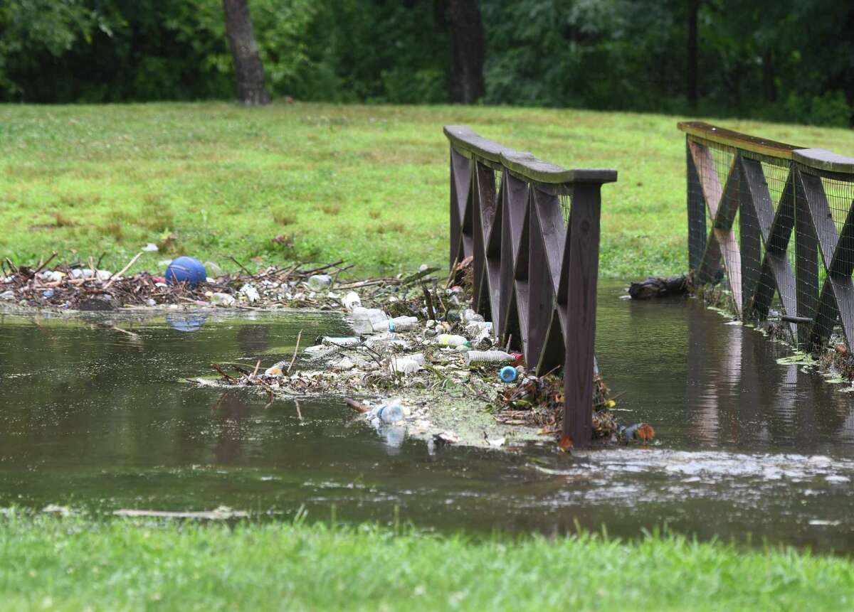 Trash from Binney Park Pond collects in a stream after the pond experienced heavy flooding in Old Greenwich, Conn. Thursday, July 18, 2019.