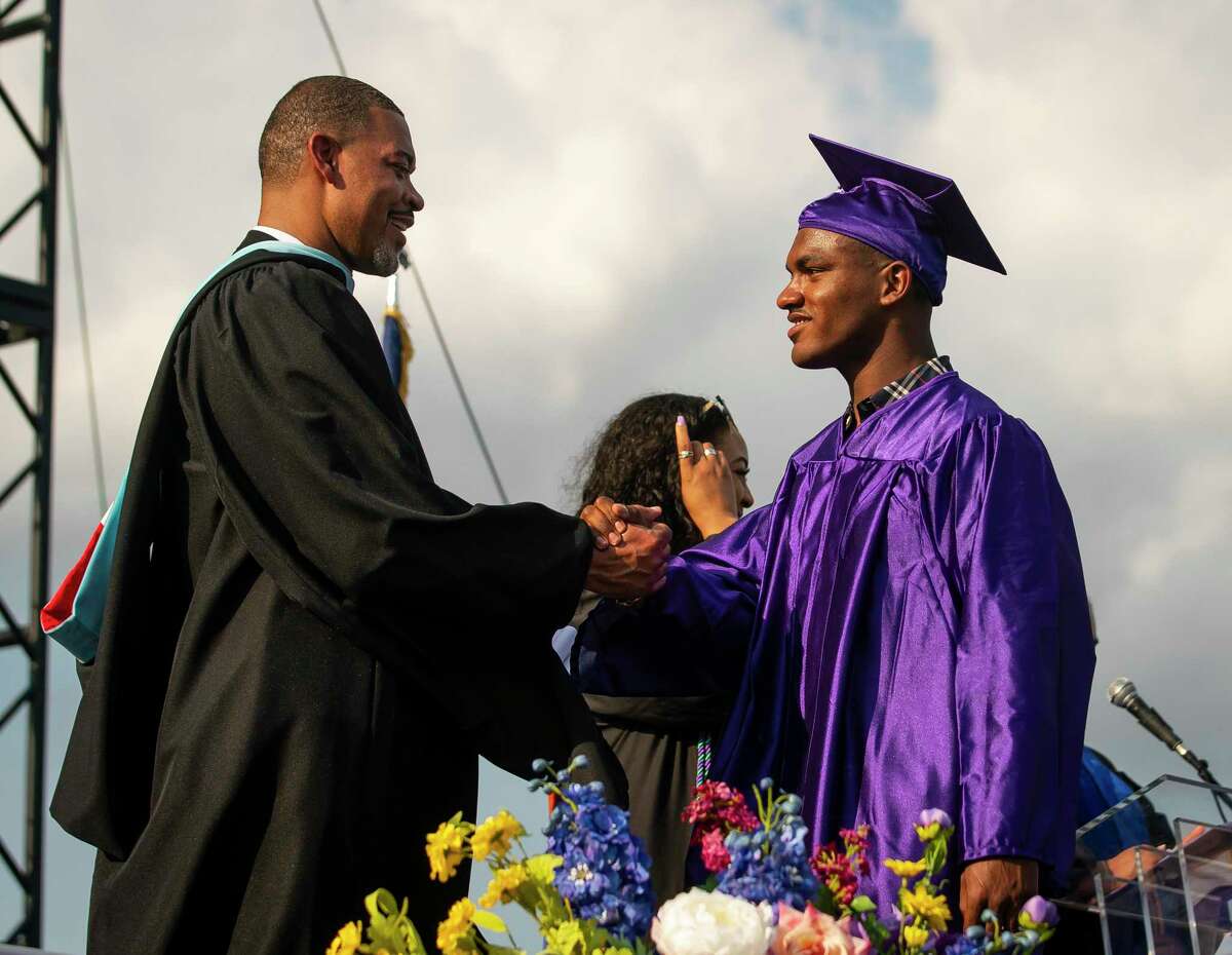 Lakeith Coleman receives his diploma from Principal Joseph Williams, Sr. during the commencement ceremony for Wheatley High School on Saturday, June 12, 2021, at Barnett Stadium in Houston.