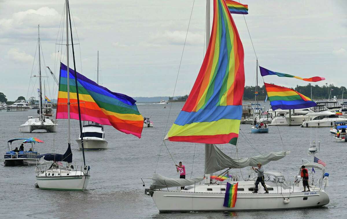 Participants in the Pride Parade of Sail motor through Norwalk Harbor Saturday.