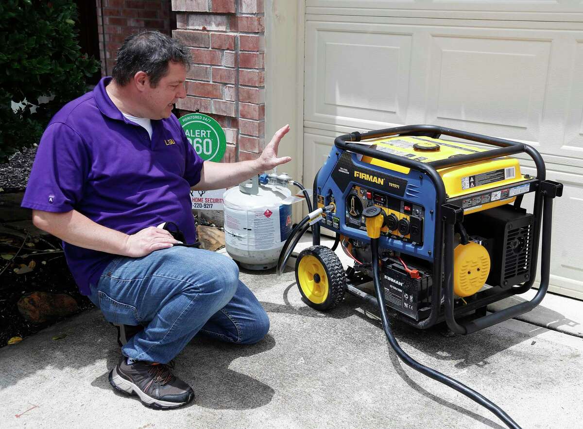 Brian Milan with his portable generator that he has retrofitted to power his home in the event of power outages, Monday, May 24, 2021, in Cypress. Milan, a Cypress resident manages a local Facebook group on retrofitting homes with portable generators.