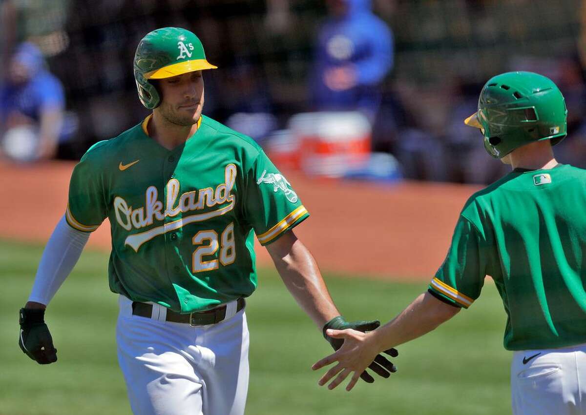 Matt Olson (28) is congratulated returning to the dugout after hitting his second solo homerun in the fifth inning as the Oakland Athletics played the Kansas City Royals at the Coliseum in Oakland, Calif., on Sunday, June 13, 2021.