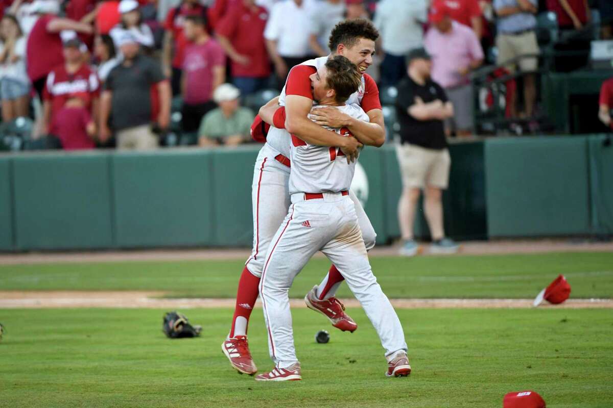 North Carolina State players Chris Villaman (left) and Tyler McDonough (right) celebrate after beating Arkansas 3-2 during an NCAA college baseball super regional game Sunday, June 13, 2021, in Fayetteville, Ark. (AP Photo/Michael Woods)