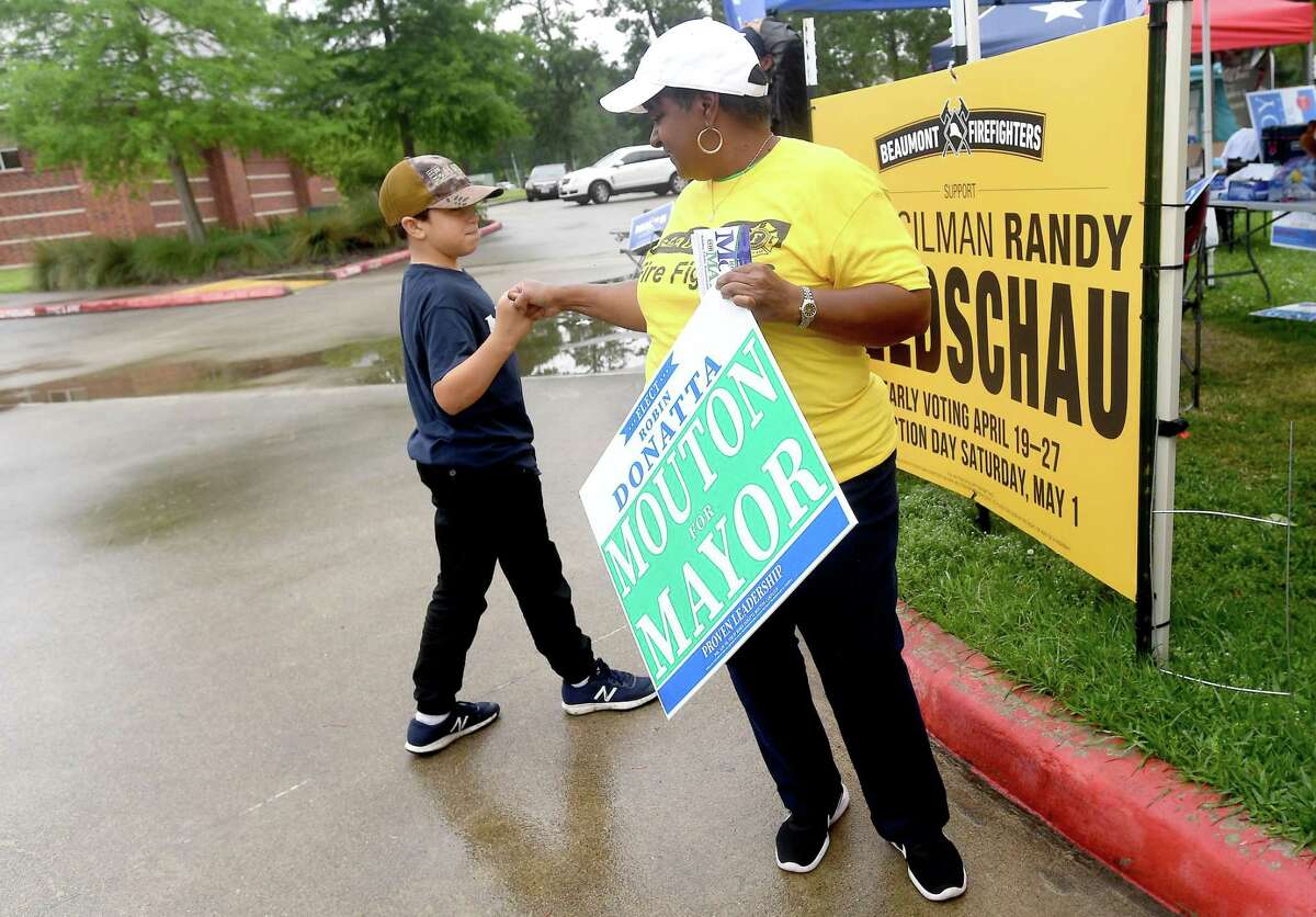 Mayorral candidate Robin Mouton gets a fist bump from a little campaigner as candidates and campaign workers make their final bid to voters on election day Saturday. Photo made Saturday, May 1, 2021 Kim Brent/The Enterprise