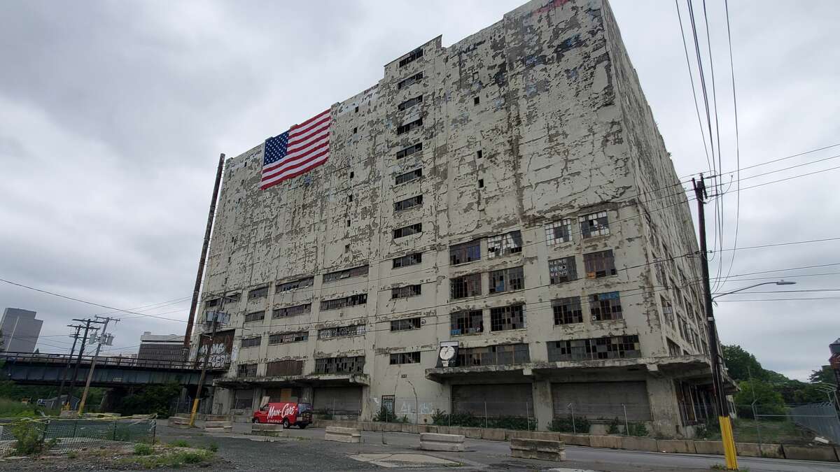 The owner of the Central Warehouse has adorned the building with an American flag to protest the county's move to take the Albany eyesore.