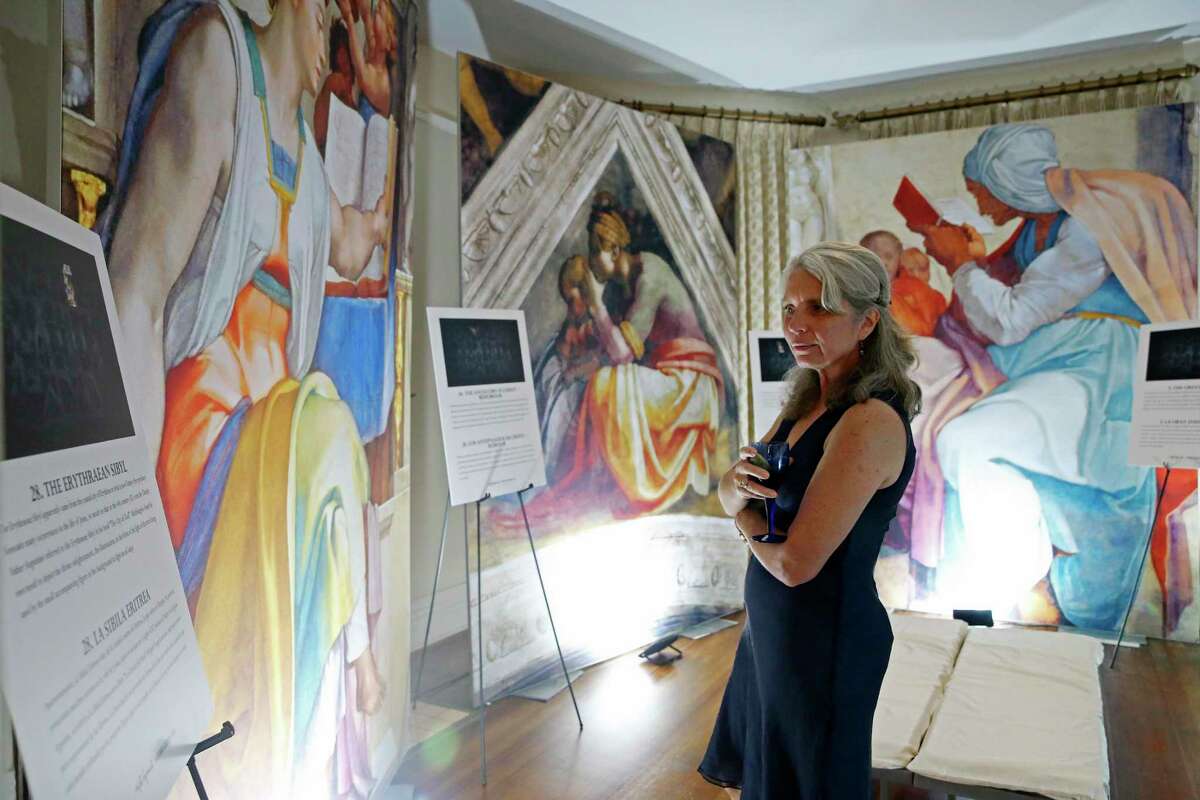 Annette Paulin attends a preview for “Michelangelo’s Sistine Chapel,” which is on display at Lambermont Events. The exhibit consists of 34 high-resolution images of the frescoes that the artist painted in the chapel.