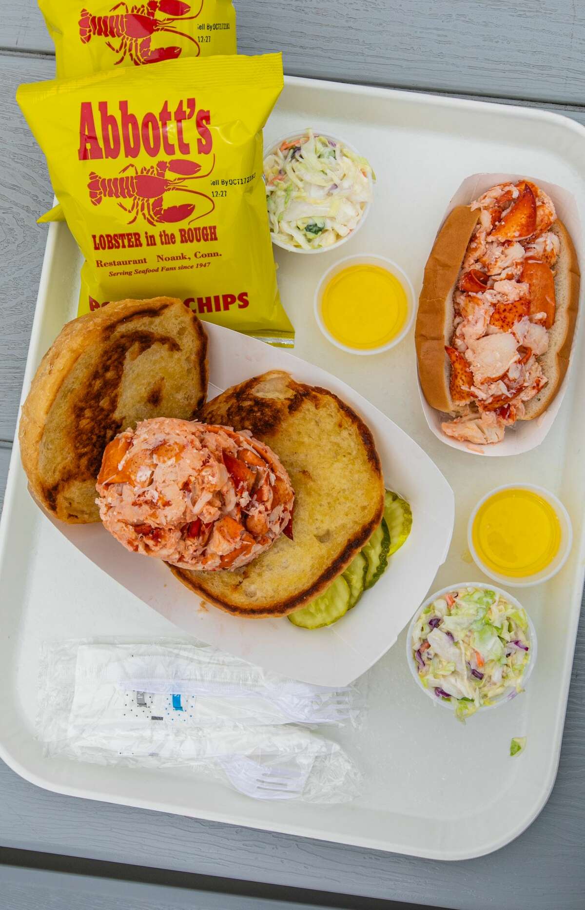 An "OMG Hot Lobster Roll" (front) and an "LOL Hot Lobster Roll" at Abbott's in Noank, Conn. on June, 2021.