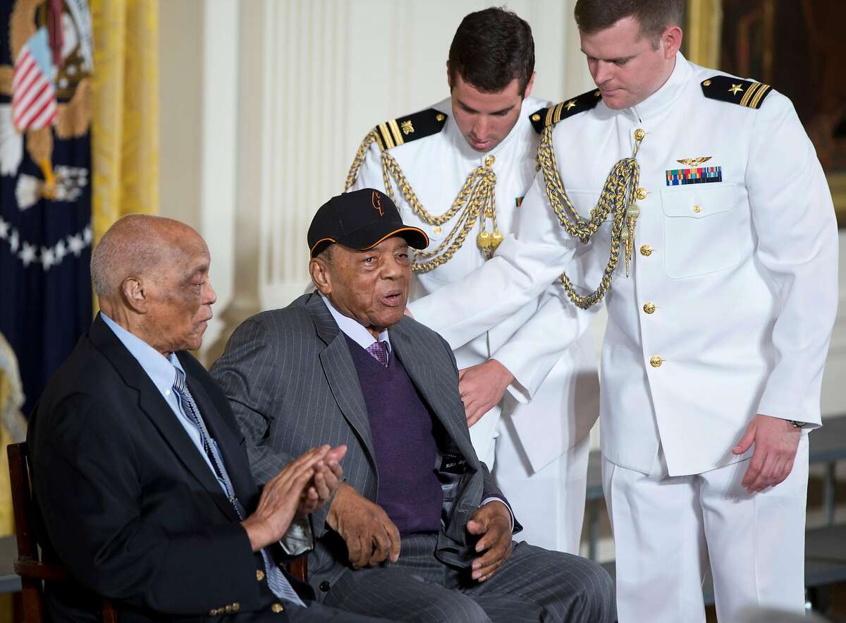 Hall of Fame baseball player Monte Irvin, left, and Willie Mays, are helped to their seats on stage in the East Room of the White House in Washington, Thursday, June 4, 2015, prior to a ceremony where President Barack Obama honored the 2104 World Series baseball champions. (AP Photo/Carolyn Kaster)