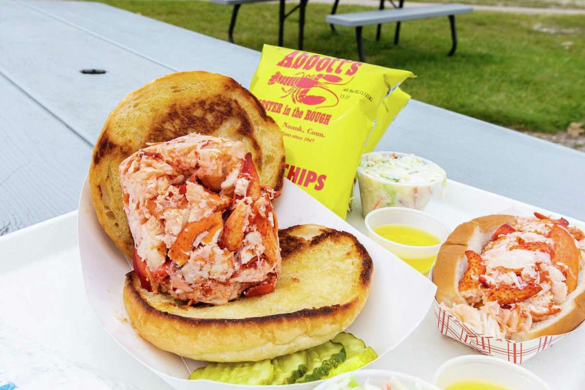 An "OMG Hot Lobster Roll" (front) and an "LOL Hot Lobster Roll" at Abbott's Lobster in the Rough in Noank.