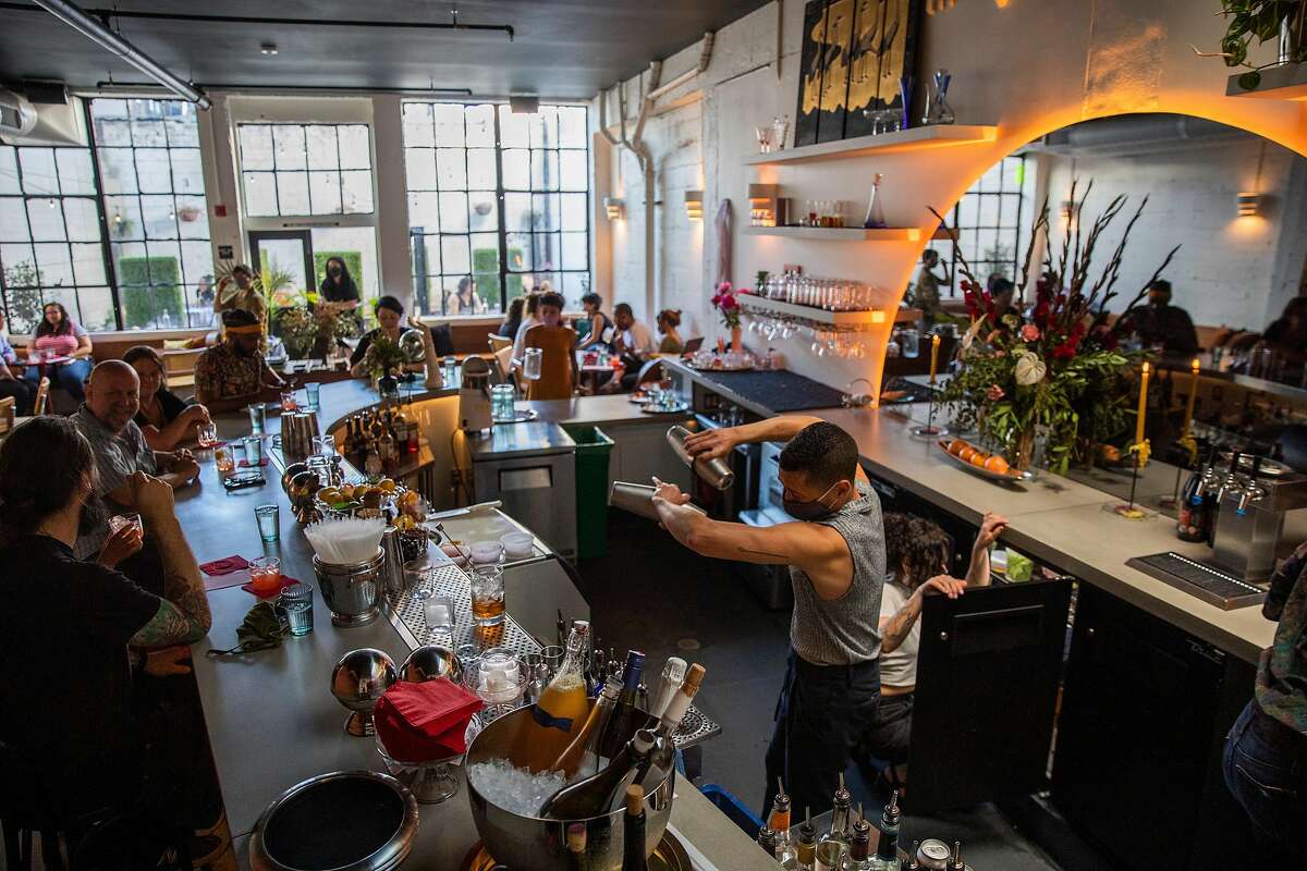 Julian Arreola (center) makes drinks for customers at Friends & Family in Oakland.