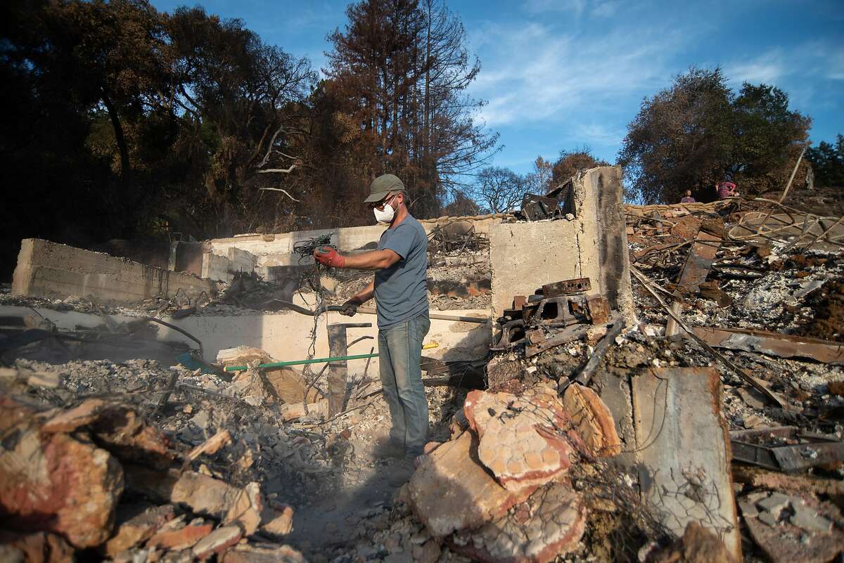 Chris Jones sifts through the remains of Jon and Elizabeth Payne’s house in Boulder Creek on Nov. 1, 2020. Payne is an accomplished musician who had just finished work on a home studio when the CZU Lightning Complex Fire swept through and destroyed his house. Jones has known Payne since they were 12 and was renting from him at the time of the fire. The Paynes plan on rebuilding their residence, which was an unofficial musician’s retreat of sorts.