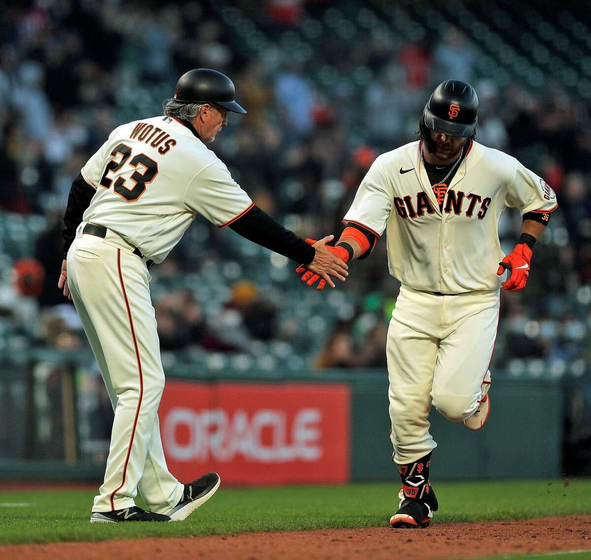 Brandon Crawford (35) high fives third base coach Ron Wotus (23) after hitting his two-run homerun in the fifth inning as the San Francisco Giants played the Arizona Diamondbacks at Oracle Park in San Francisco, Calif., on Monday, June 14, 2021.