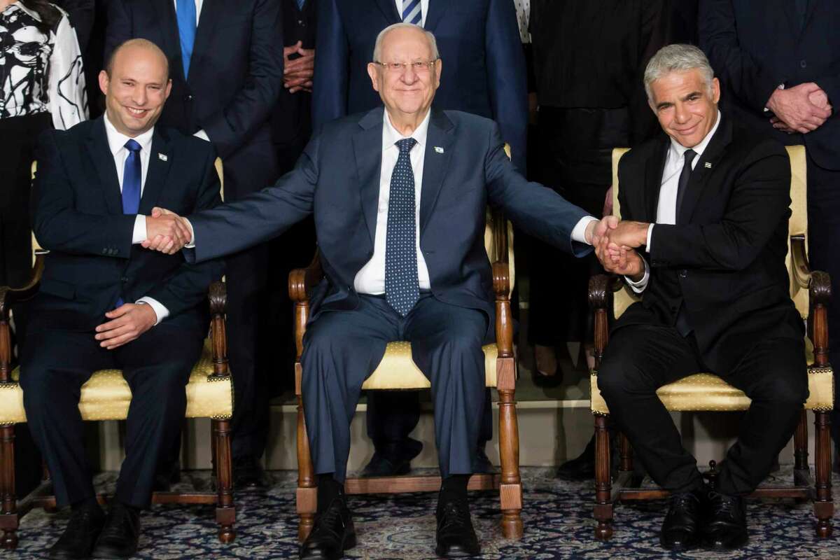 JERUSALEM, ISRAEL - JUNE 14: Israeli President Reuven Rivlin (C) sits next to Israeli Prime Minster Naftali Bennett (L) and Foreign Minister Yair Lapid (R) as they pose for a group photo with minsters of the new Israeli government on June 14, 2021 in Jerusalem, Israel. A disparate coalition of parties forged a governing coalition to end Benjamin Netanyahu's 12-year prime ministership and two years of inconclusive elections. (Photo by Amir Levy/Getty Images) *** BESTPIX ***