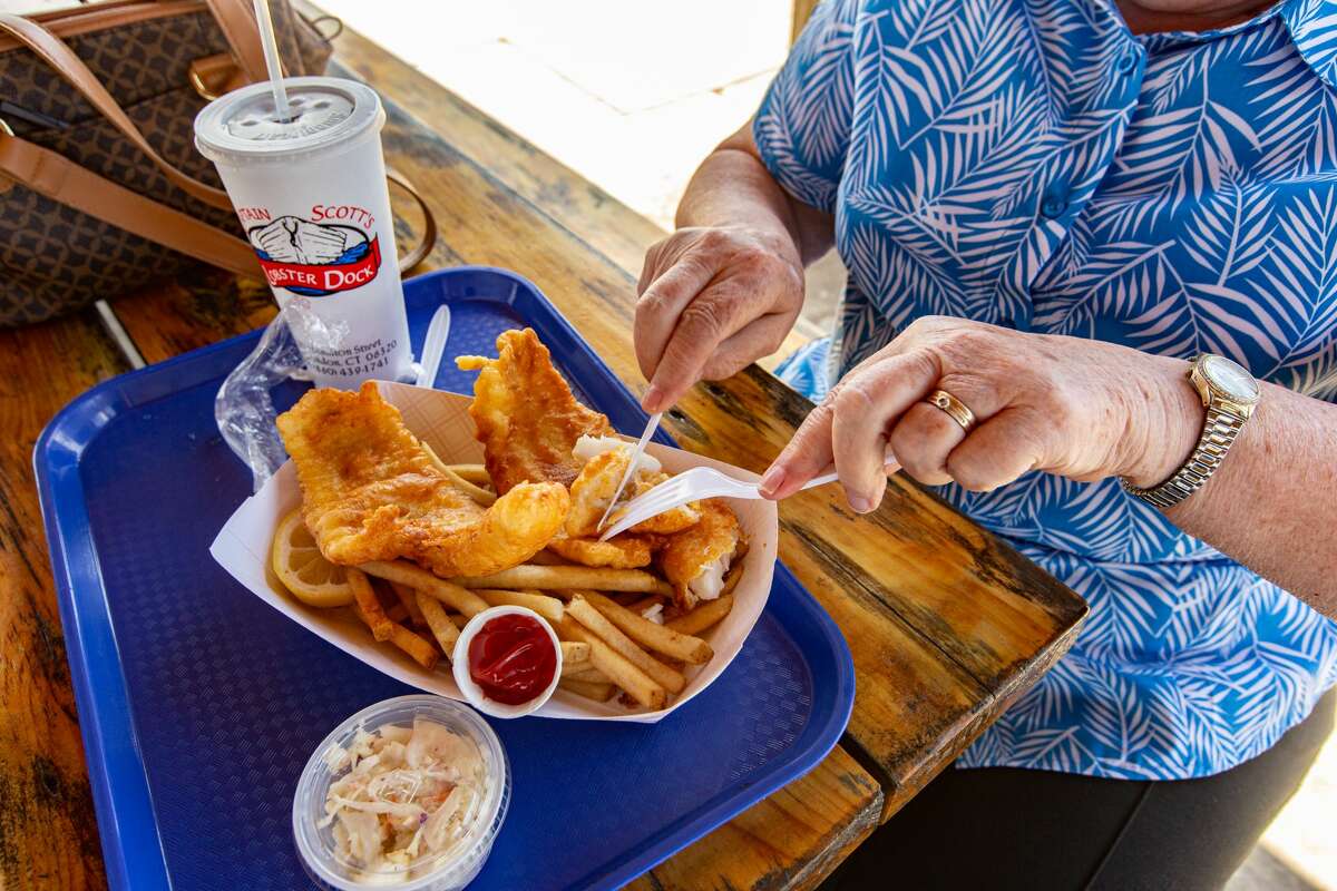 A customer digs in to fish and chips at Captain's Scott's Lobster Dock in New London, Conn., on May 27, 2021.
