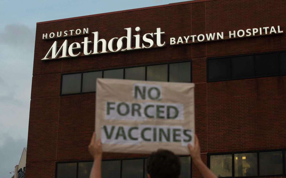 People bring signs to protest Houston Methodist Hospital system’s rule of firing any employee who is not immunized by Monday, June 7, 2021, at Houston Methodist Baytown Hospital in Baytown. Houston Methodist staff who have refused the COVID-19 vaccine so far and their supporters participated a gathering and march.