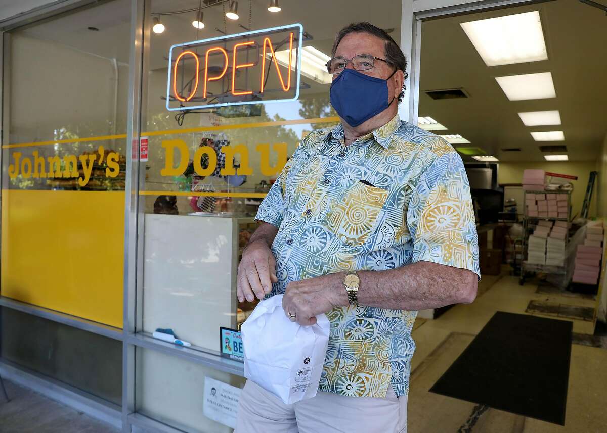 Conrad Breece holds a bag of doughnuts purchased from Johnny’s Donuts in Lafayette as he celebrates his 78th birthday in June. The retired attorney says he was kicked out of a grocery store two months ago for not donning a mask. He still wears one.“My attitude right now is I’m going to wear my mask as long as people expect me to,” Breece says.