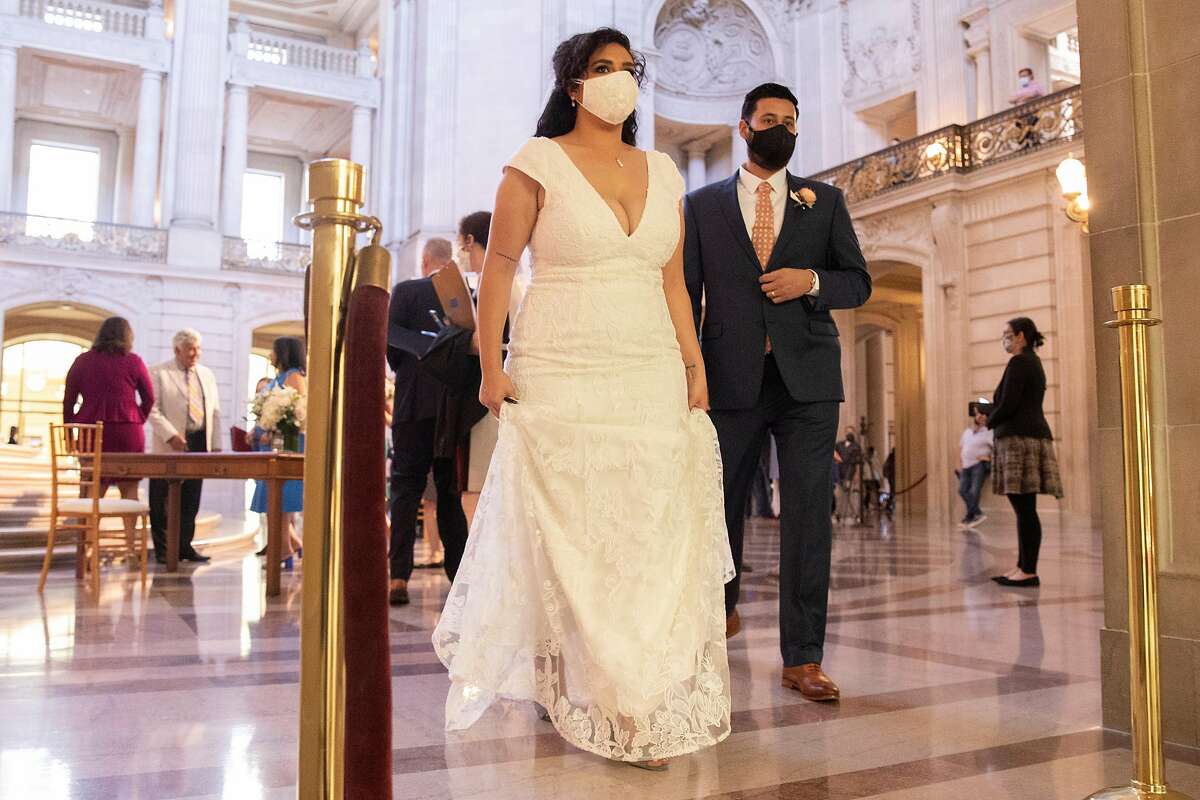 Eric Lara and Iyah Turminini wear masks after being married by Mayor London Breed during the very first indoor City Hall marriage ceremonies since the start of the pandemic following a Pride month kickoff celebration at San Francisco City Hall in San Francisco, Calif. Monday, June 7, 2021.