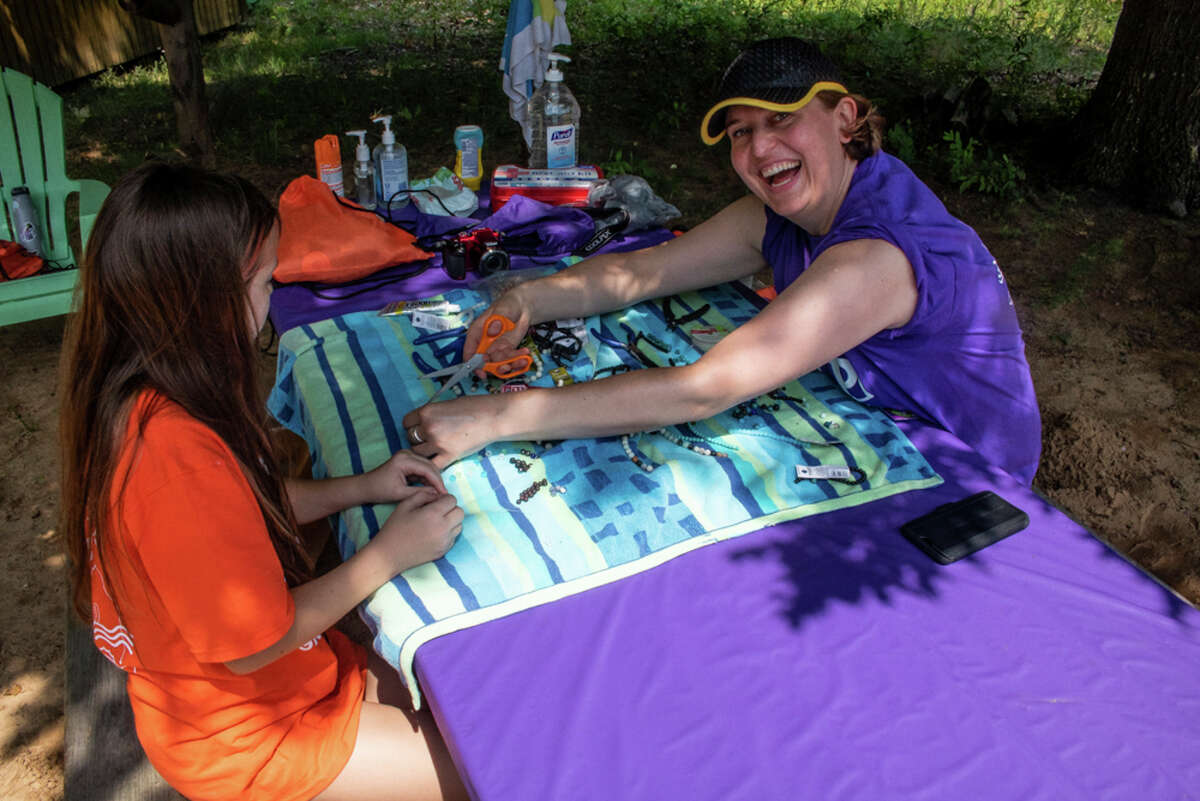 Monika Gawlak-Klump, right, helps Zoe Jackson, left, make a bracelet during Camp Grief, Grit and Hope, hosted by Children's Grief Center of the Great Lakes Bay Region, on June 12, 2021 at the Lazy Turtle Ranch in Sanford. (Aurora Abraham/aurora.abraham@hearstnp.com)