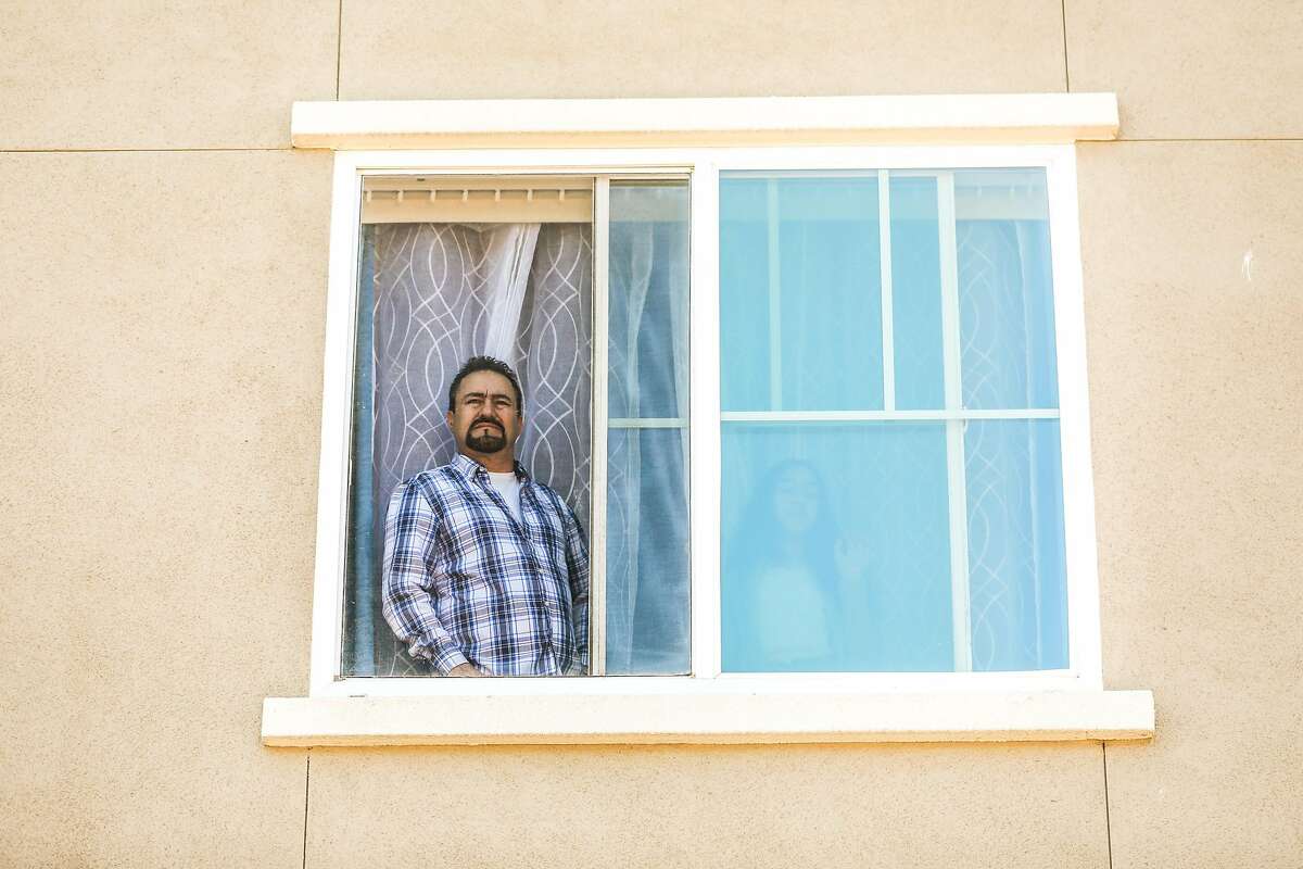 A man watches the “Reopening of the State Celebration” party from his window in Colma. The party was to celebrate the first day that vaccinated people could move around both indoors and outdoors without masks.