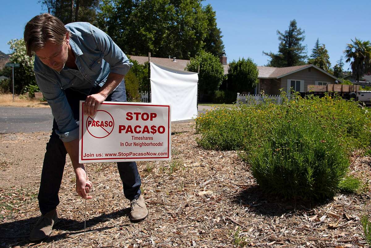 Brad Day places an anti-Pacaso sign at the corner of his Sonoma cul-de-sac in protest to the start up company’s actions in his neighborhood.