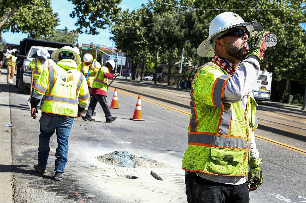 Joey Valles drinks from bottled water while working to install a telecommunication line on First Street in San Jose, Calif. on Wednesday, June 16, 2021. The National Weather Service is issuing heat warnings for most of the Bay Area and surrounding counties for the next several days.