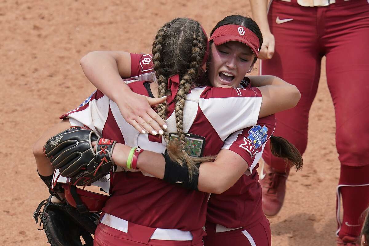 Oklahoma pitcher Nicole May, right, celebrates with catcher Kinzie Hansen, left, after Oklahoma defeated James Madison in an NCAA Women's College World Series softball game Sunday, June 6, 2021, in Oklahoma City. (AP Photo/Sue Ogrocki)
