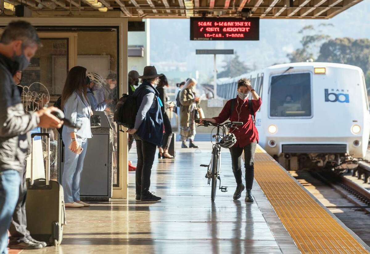 Morning commuters wear masks while waiting for a San Francisco bound BART train at MacArthur station in Oakland on June 15, 2021.