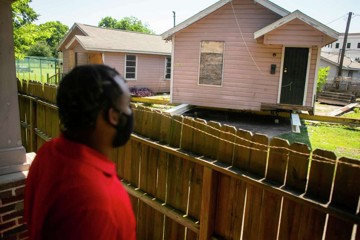 Benjamin Smith looks out onto one of the properties owned by Change Happens CDC, a local nonprofit founded by his father, Rev. Leslie Smith, on Wednesday, June 16, 2021. Change Happens CDC buys, moves and builds properties to ensure residents in Third Ward have affordable housing options.