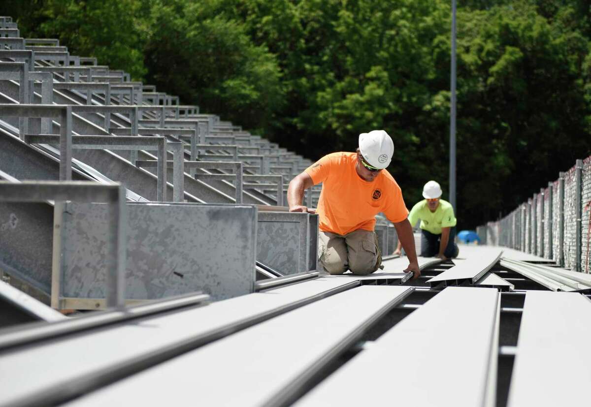 Zach Carroll lays down aluminum flooring on the bleachers at Greenwich High School's Cardinal Stadium in Greenwich, Conn. Wednesday, June 16, 2021. While the bleachers will not be done in time for next week's graduation, the beginning of the physical construction marks a major milestone in the Cardinal Stadium improvement project.