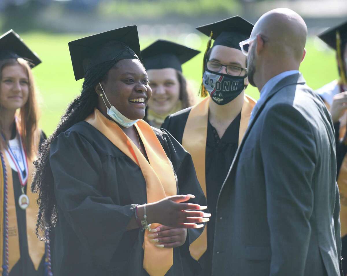 Chloe Fleurantin shares a laugh with school counselor Josh Bogard at the Academy of Information Technology & Engineering (AITE) 2020-2021 commencement ceremony at the AITE campus in Stamford, Conn. Wednesday, June 16, 2021.