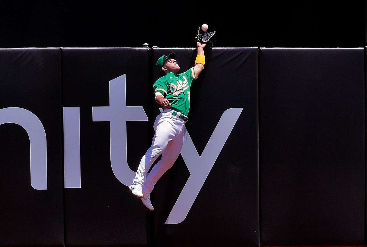 Top: Laureano makes a two-footed leap to the top of the wall to snare a drive from Justin Upton in the fourth.