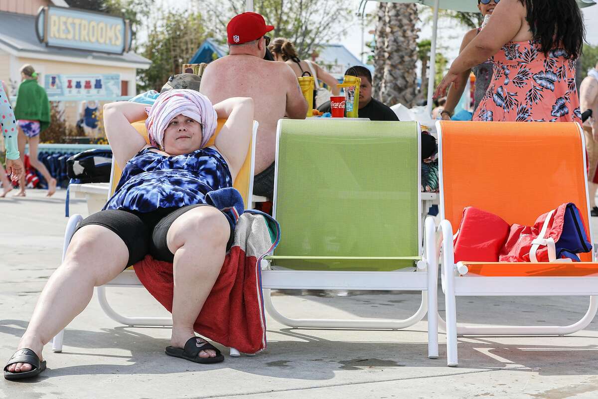 Ashley Giovacchini lounges near the pool at South Bay Shores water park at California’s Great America in Santa Clara, Calif. on Wednesday, June 16, 2021. The water park opened on June 5 after having post poned their opening day last year due to the pandemic. The water park includes slides, a lazy river and wave pool offering solace to visitors beating the heat after the National Weather Service is issuing heat warnings for most of the Bay Area and surrounding counties for the next several days.