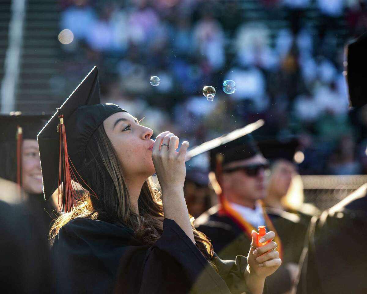 Shelton High School graduate Ashley Coppola blows bubbles during graduation for the Class of 2021 on June 16, 2021.