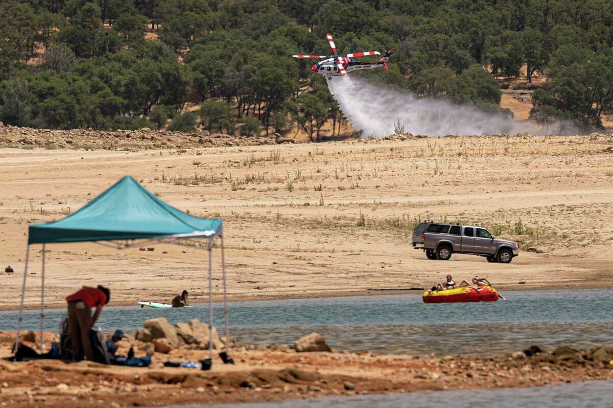 A CalFire helicopter practices water drops along Folsom Lake in Granite Bay, Calif., on June 16, 2021.