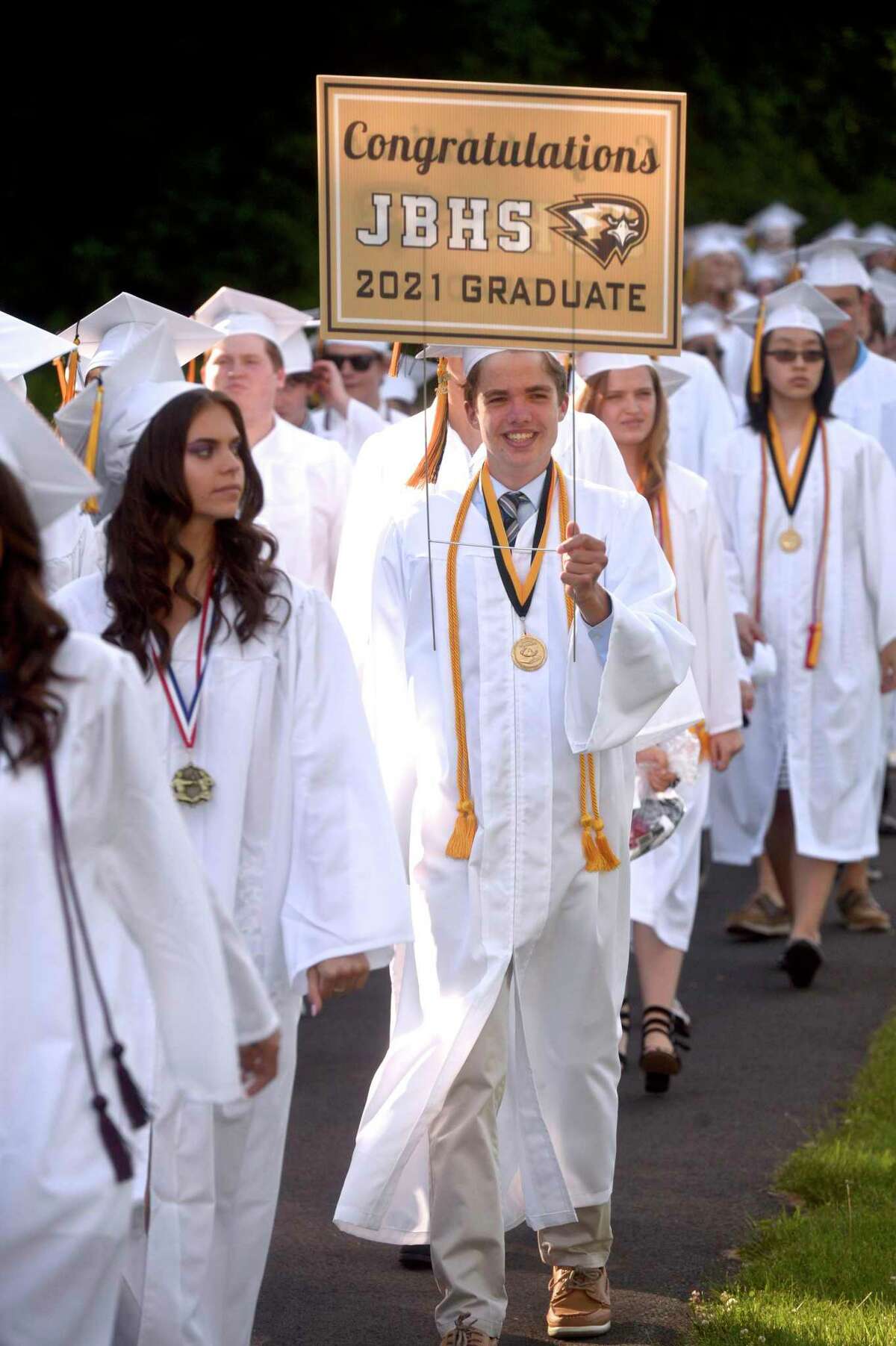Ayden Patrick Kloiber grabbed a sign on the walk from the school to the stadium for the Joel Barlow High School Class of 2021 Commencement Ceremony. Wednesday, June 16, 2021, in Redding, Conn.