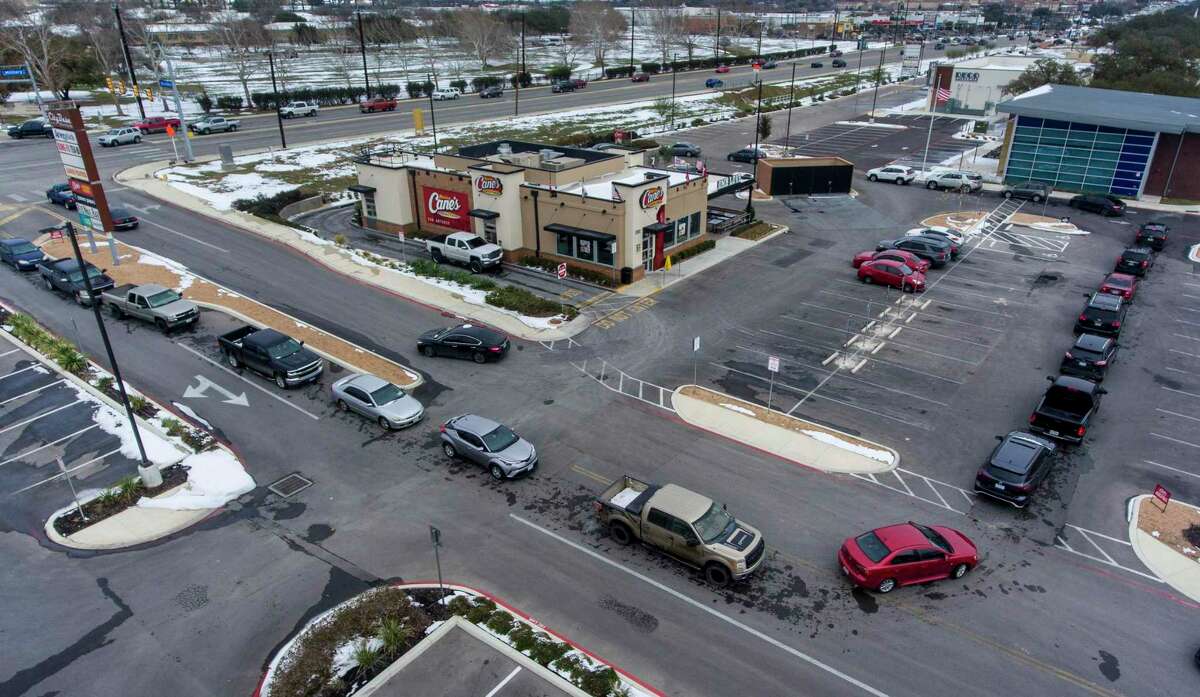 Vehicles encircle a Raising Cane's Chicken Fingers restaurant Tuesday, FEb. 16, 2021 on SE Military Dr. near S. Presa St. With as many as 38 percent of CPS Energy customers without power, long lines formed around the fast food restaurants who had power and were open.