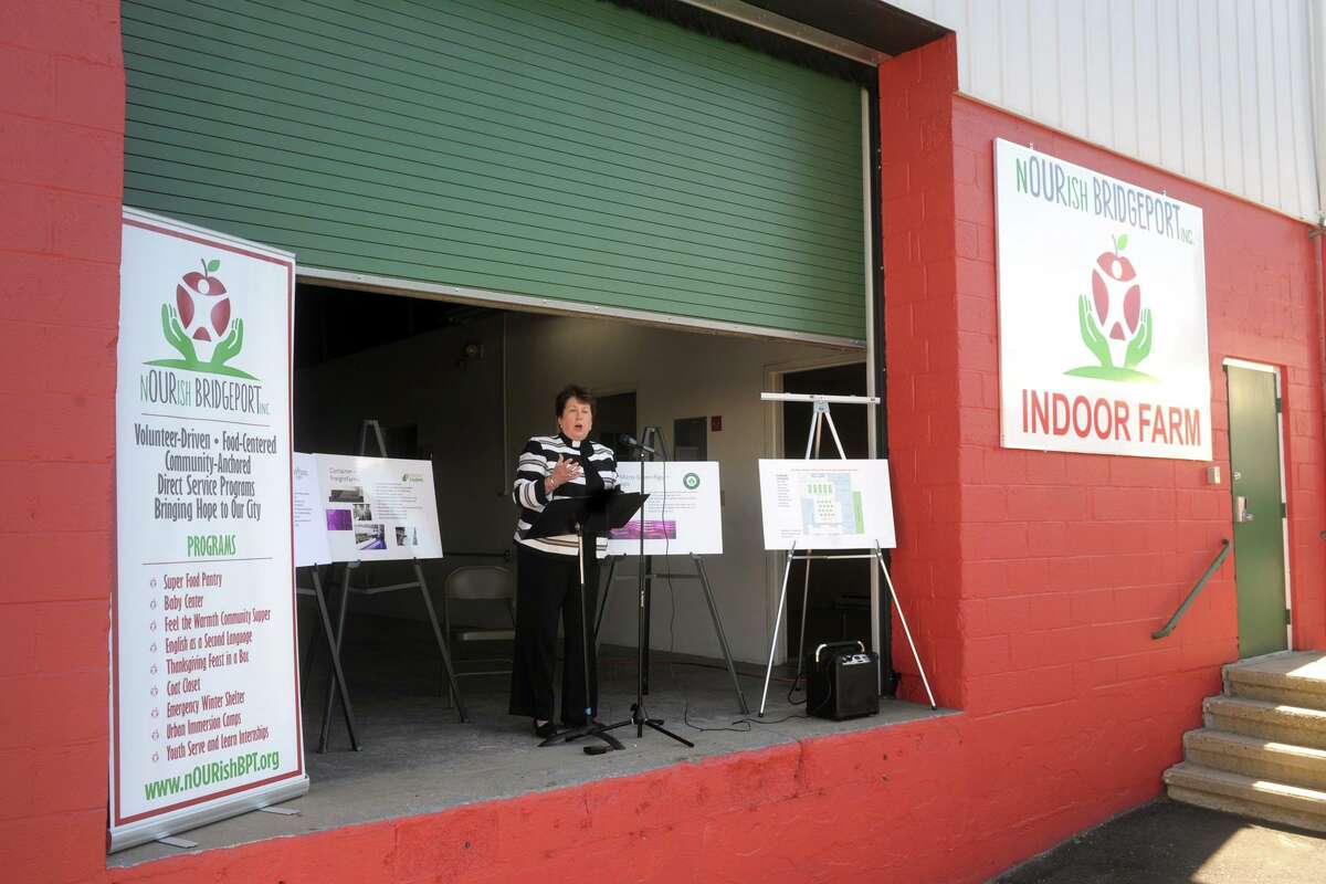 Rev. Sara Smith, founder and CEO of nOURish BRIDGEPORT, speaks from the loading dock of the non-profit’s new location during a ribbon cutting ceremony in Stratford, Conn. June 16, 2021. The building will soon be converted indoor vertical hydroponic farm.