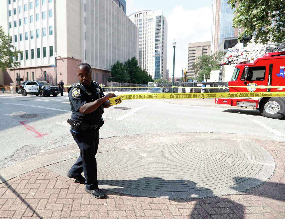 A Harris County Precinct 1 Sheriffs Deputy puts up crime scene tape across the street as Houston firefighters and investigators were on the scene at Preston and Caroline, after construction workers located, what they believe to be a cannonball or other potential explosive device, Thursday, June 17, 2021.