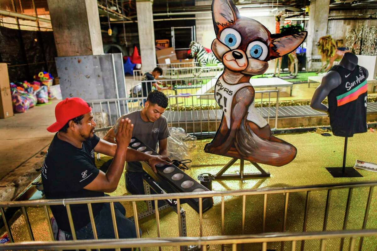 Douglas Varaona, left, and Selvin Reyes work on a San Antonio Spurs-theme float for the Texas Cavaliers River Parade at the River Walk’s Old Marina on Thursday. Fiesta kicked off with its only other parade this year, honoring front-line hospital workers at Hemisfair Park.