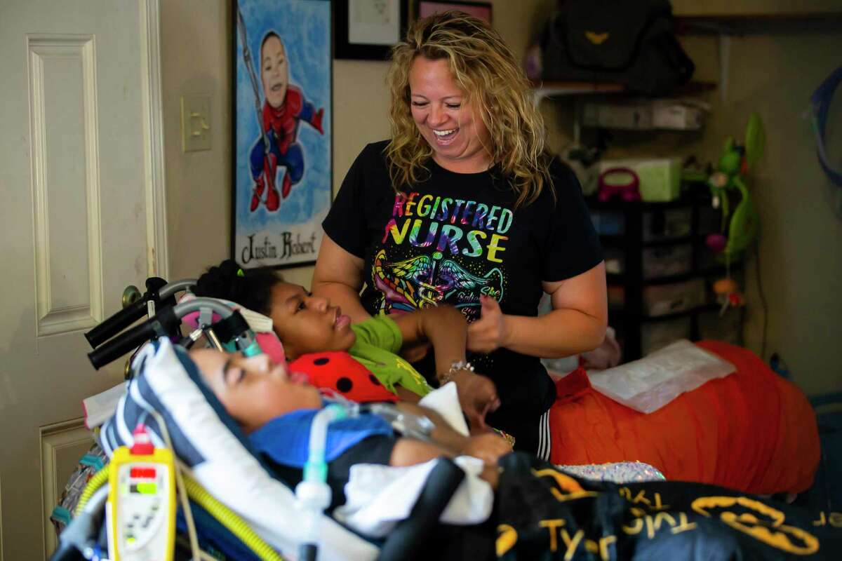 Nurse Brenda Bello plays with Hailey Cheevers, 11, in the Cheevers’s Willowbend home on Thursday, June 17, 2021.