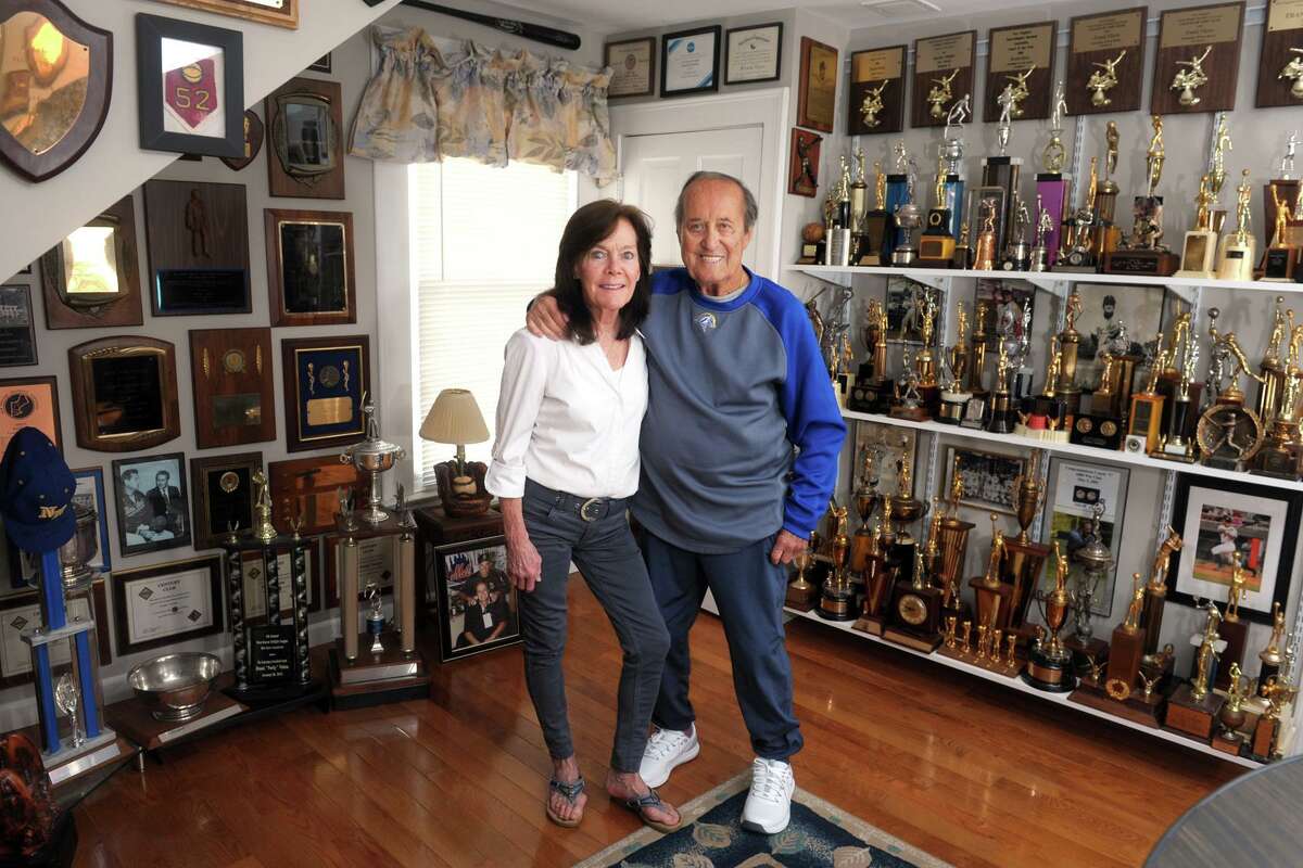 Former University of New Haven baseball coach Frank “Porky” Vieira and his wife Laura pose in the trophy room of their home in West Haven.