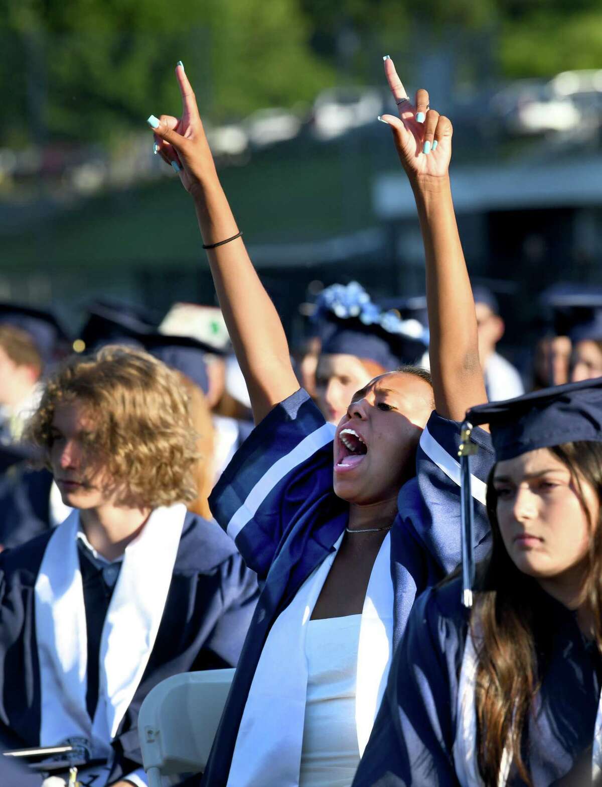 Nicole Holmes cheers for fellow graduates at Staples High School graduation ceremonies held on the school's football field, Thursday, June 17, 2021 in Westport.
