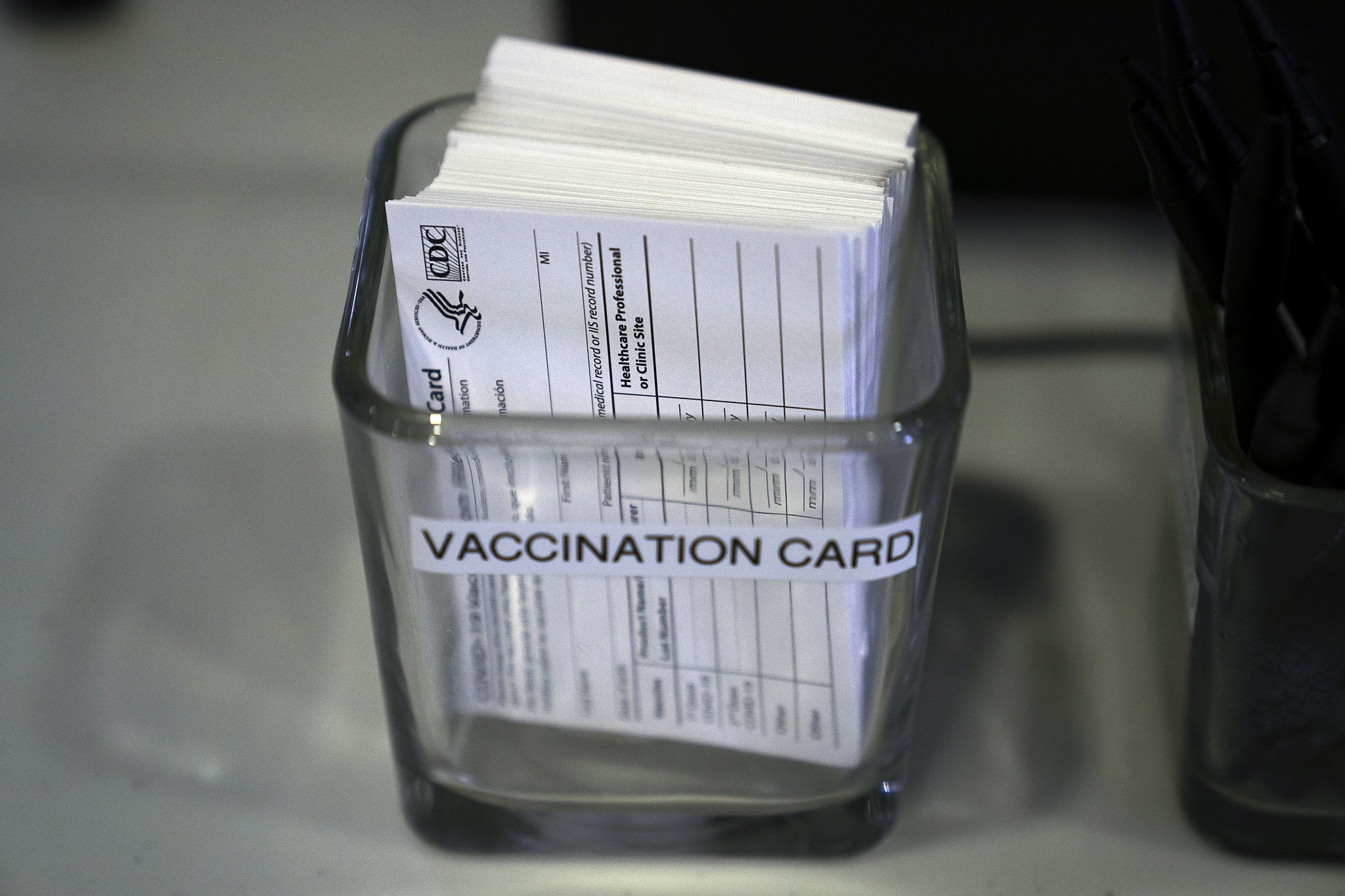 COVID-19 vaccination cards are displayed on a check-in table in Santa Ana on May 21, 2021. California will introduce a digital verification tool that 