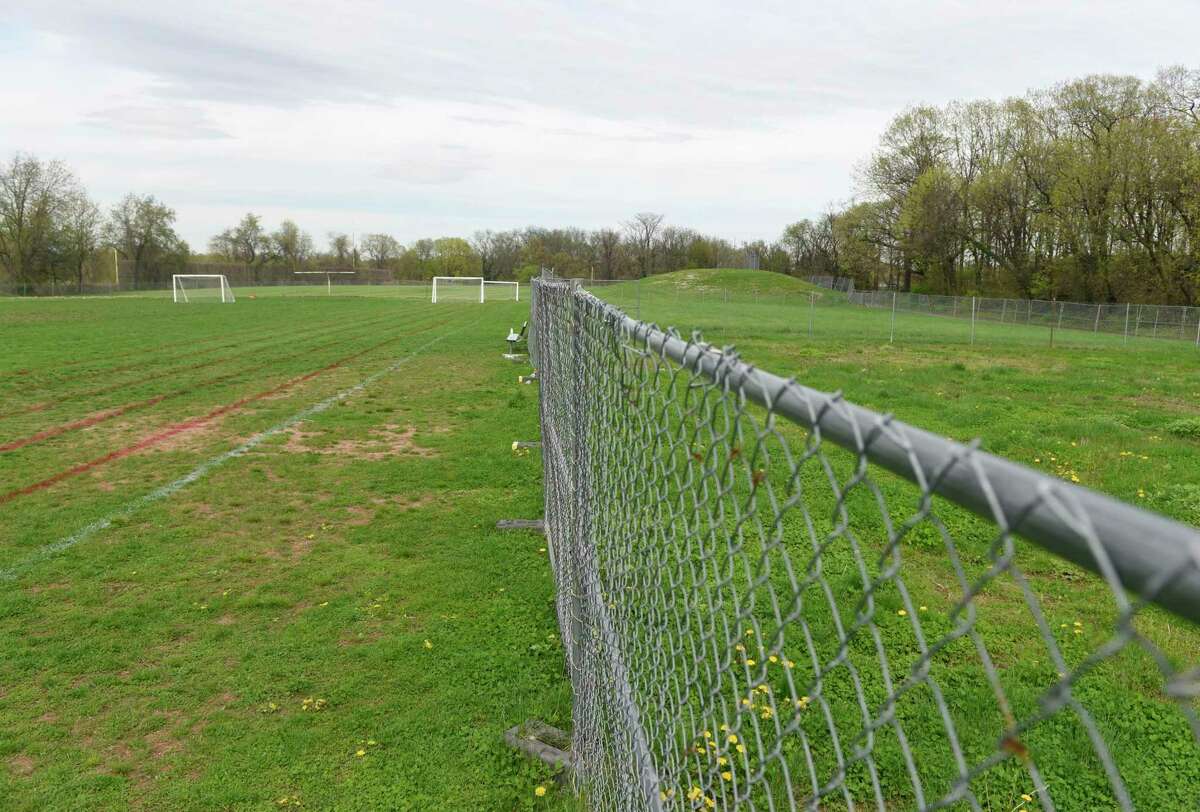 A fence divides the useable section of field, left, from the unuseable, contaminated section at Western Middle School in Greenwich, Conn. Thursday, April 25, 2019.