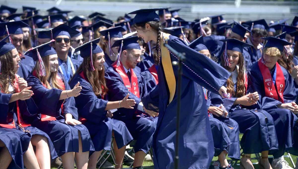 Class Valedictorian Anna Kozloski gets high fives on the way back to her chair after giving her address during the New Fairfield High School Class of 2021 Commencement Exercises. Friday morning, June 18, 2021, in New Fairfield, Conn.