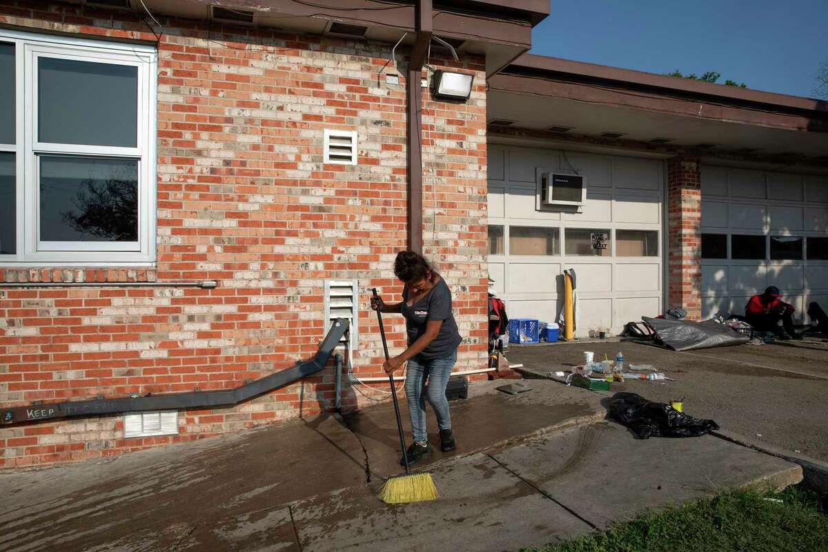 Rosa cleans a section of a sidewalk next to the District 1 field office parking lot where unsheltered people of have been camping. Rosa, who does not sleep at the parking lot anymore, wants to help keep it clean for her friends that are still there.